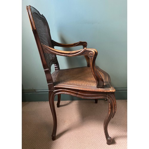 48 - A caned armchair in the French style with carved cabriole front legs. 101 h x 60cm w.