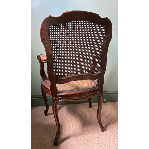 48 - A caned armchair in the French style with carved cabriole front legs. 101 h x 60cm w.