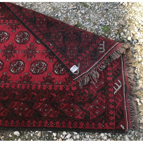 1134 - An Oriental runner, predominately red. 192 l x 114cm w.