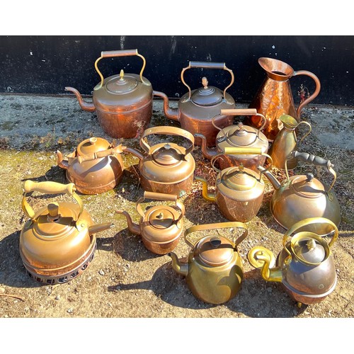 948 - Assorted copper and brassware to include eleven kettles and two jugs. (13)