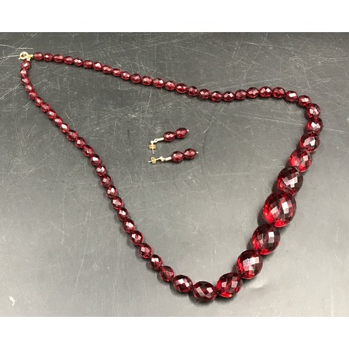 543A - Faceted cherry amber beads and a pair of matching earrings, necklace measures approx 74cm l, drop in... 