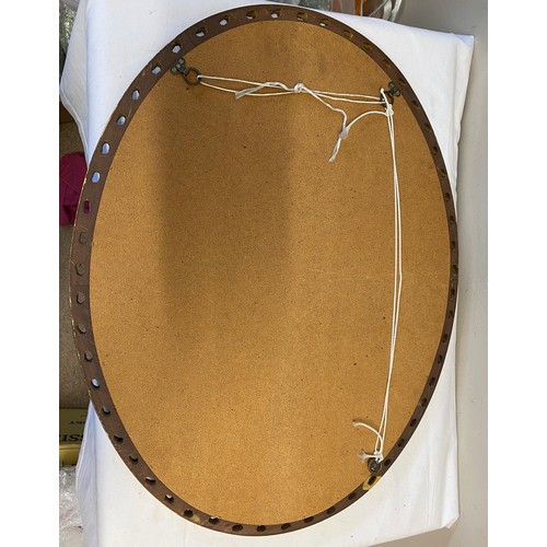 1142 - A gilt framed oval mirror. 67 x 52.5cm.