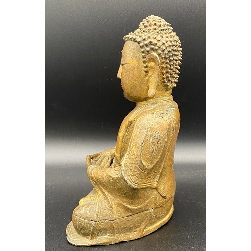 762 - An antique gilded bronze Shakyamuni Buddha believed to be pre 19thC seated in padmasana, his hands i... 