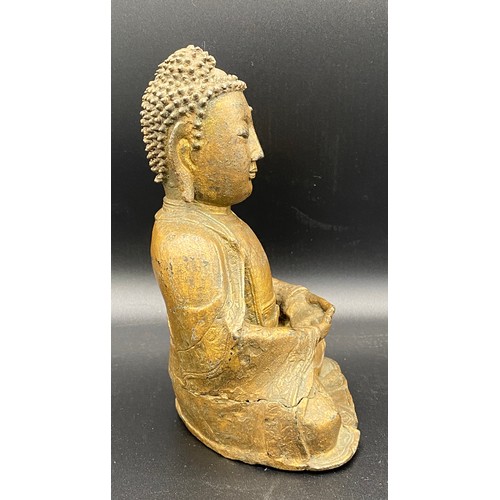 762 - An antique gilded bronze Shakyamuni Buddha believed to be pre 19thC seated in padmasana, his hands i... 