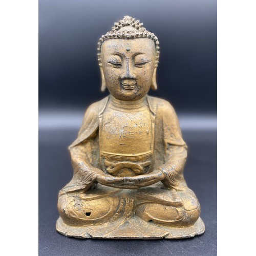 762 - An antique gilded bronze Shakyamuni Buddha believed to be pre 19thC seated in padmasana, his hands i... 