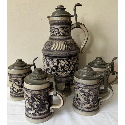 943 - Large German pewter lidded jug and four pewter lidded steins. Jug 38cm h.