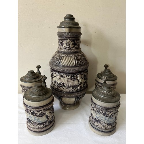 943 - Large German pewter lidded jug and four pewter lidded steins. Jug 38cm h.