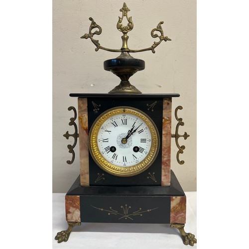 1019 - A 19thC French black and pink marble mantle clock on brass lion's paw feet. 39 x 22cm w.