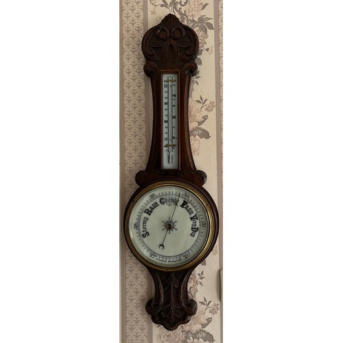 1182 - An oak aneroid barometer with thermometer. 84 h x 26cm w together with a gilt and green Kundo annive... 