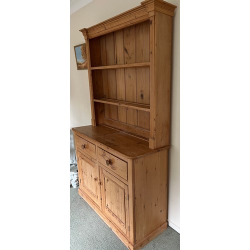 73 - Pine dresser with 2 drawers over 2 cupboards and rack to back. 125w x 43d x 198h.