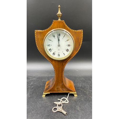 1181 - An Edwardian mahogany inlaid mantel clock with brass feet, finial and key.