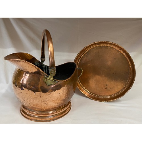 1055 - Copper tray and hammered copper coal helmet. Helmet 27cm h. Tray measuring 36cm d.