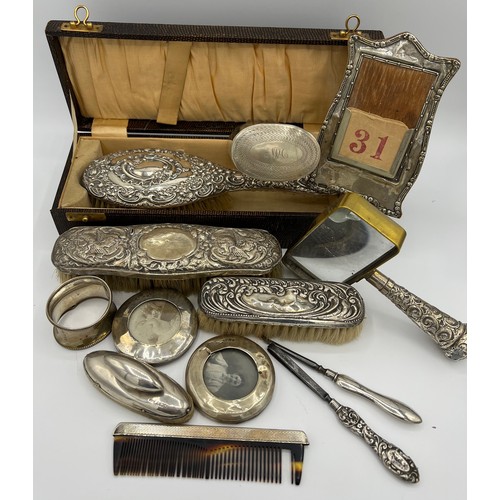 749 - A quantity of silver to include boxed hairbrush, clothes brushes, napkin ring, nail buffer, comb, de... 