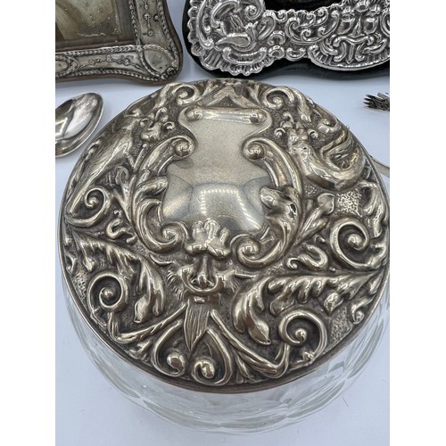 750 - Two silver photograph frames, one modern, a silver topped glass jar, white metal tongs and a silver ... 