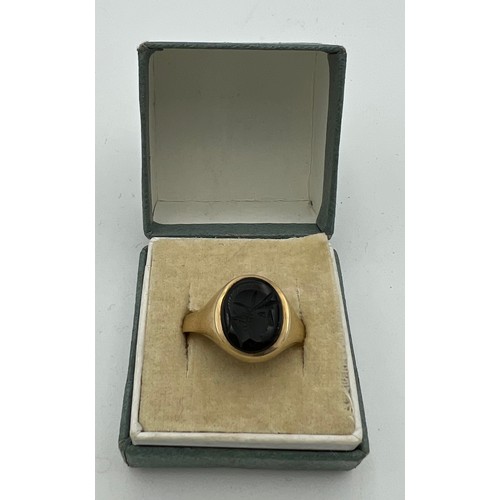 525 - A 9 carat gold signet ring inset with jet depicting centurion's head. Total weight 2.8gm.