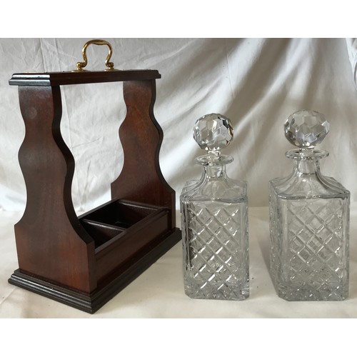 421 - An open wooden tantalus 37 h x 17cm w holding two cut glass decanters with stoppers 26 h x 10cm w al... 