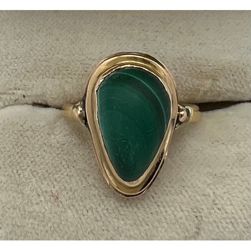 551 - A yellow metal ring set with malachite. Size L. Weight 4.5gm.