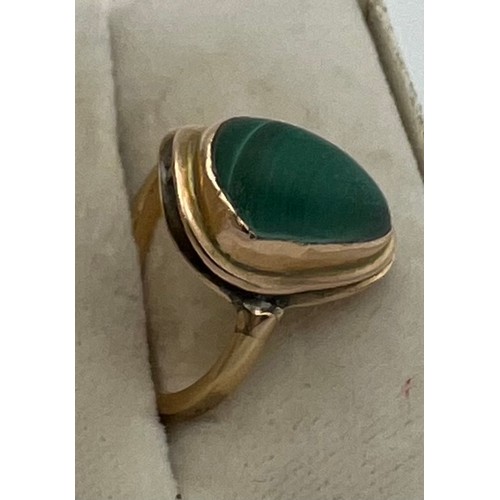 551 - A yellow metal ring set with malachite. Size L. Weight 4.5gm.