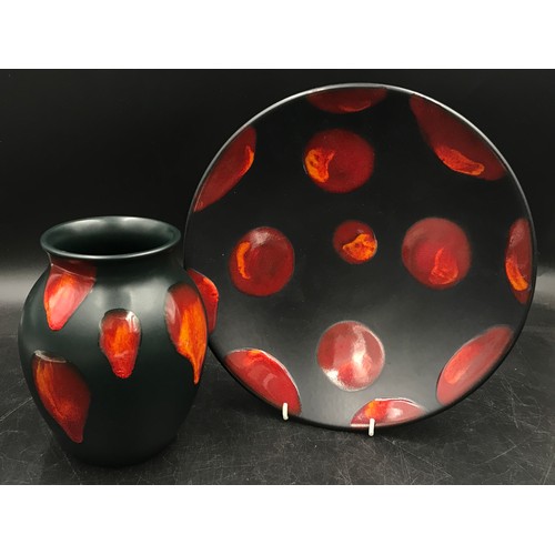 328 - Poole pottery to include a black plate and vase both with red lava drip pattern. Plate 26.5 w and va... 