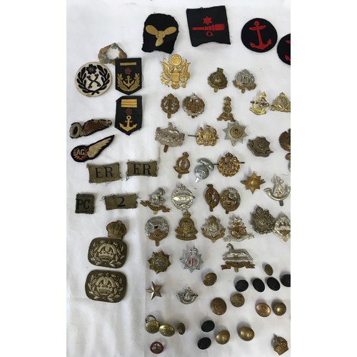 1202 - A collection of WWI and WW2 cap badges and shoulder titles to include RAF, Royal Navy, Japanese etc ... 