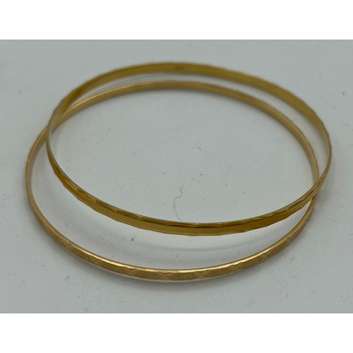 557 - Two 18 carat yellow gold bangles, total weight 14.6gm, diameter 7cm.