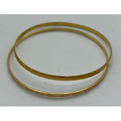 557 - Two 18 carat yellow gold bangles, total weight 14.6gm, diameter 7cm.