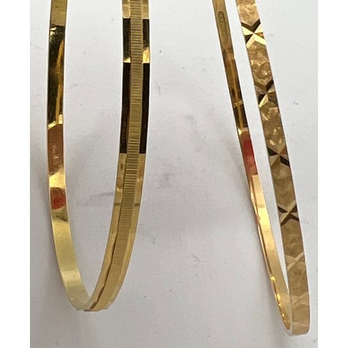 557 - Two 18 carat yellow gold bangles, total weight 14.6gm, diameter 7cm.