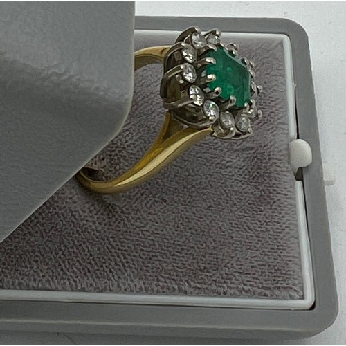 559 - An emerald and diamond cluster ring set in 18 carat yellow gold. Size N, weight 6.9gm. Emerald appro... 