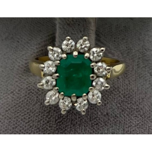 559 - An emerald and diamond cluster ring set in 18 carat yellow gold. Size N, weight 6.9gm. Emerald appro... 