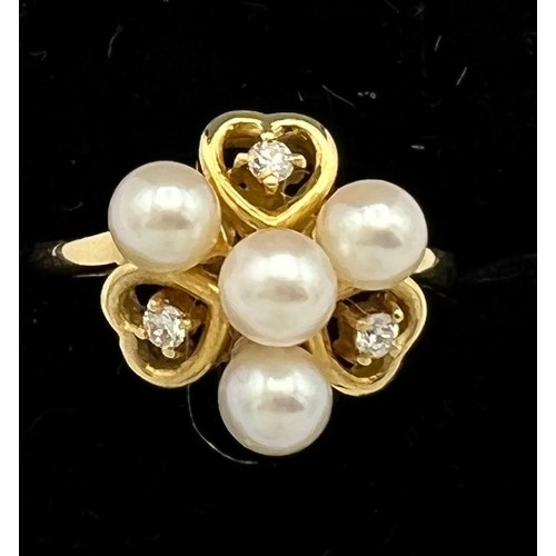 575 - An eighteen carat gold ring set with cultured pearls and diamonds. Size M. Weight 2.8gm.