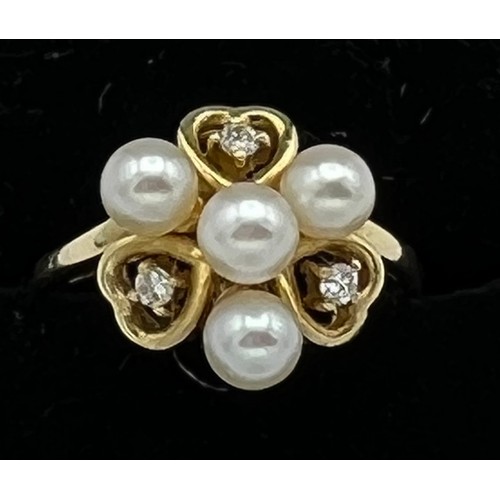 575 - An eighteen carat gold ring set with cultured pearls and diamonds. Size M. Weight 2.8gm.