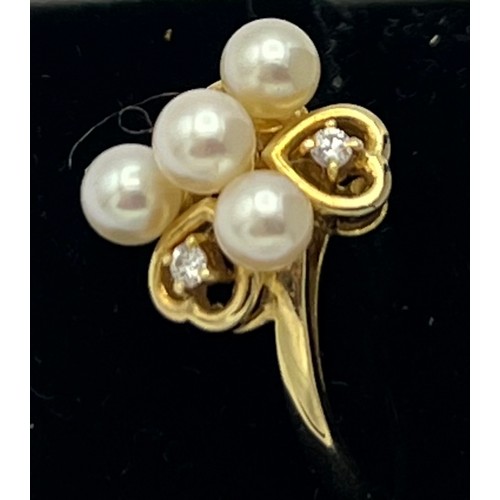 575 - An eighteen carat gold ring set with cultured pearls and diamonds. Size M. Weight 2.8gm.