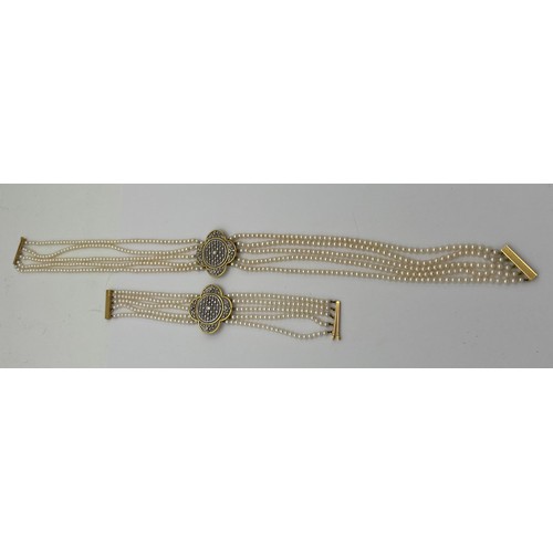 580 - A quintuple strand seed pearl choker necklace with pierced 18 carat gold, platinum and diamond set c... 