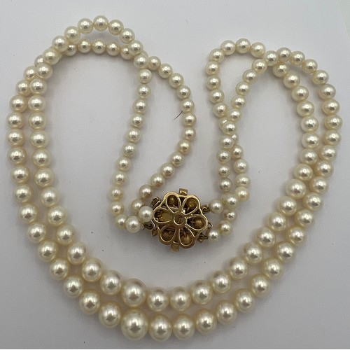 583 - Double strand cultured pearl necklace with pearl and garnet set clasp. Approximately 48cm length.