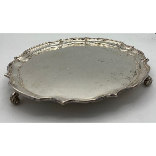 736 - A silver tray raised on scroll feet. Weight 458gm.  25cm d. Sheffield 1960 maker William Bush and so... 