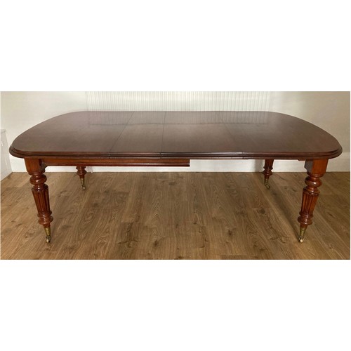 85 - A 19thC mahogany wind out dining table on fluted tapering legs and brass castors. 76 h x 121 w x 148... 