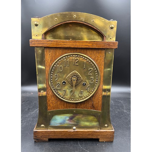 1192 - An Arts and Crafts oak and brass mantle clock. Probably Liberty. 37h x 25 w.