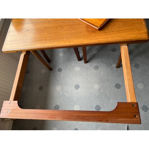 115 - A nest of 3 mid-century teak tables to include one fold over opening to form a larger table 81 x 76c... 