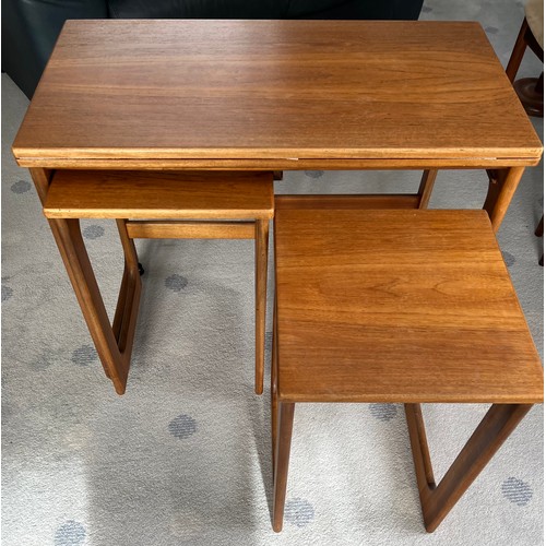 115 - A nest of 3 mid-century teak tables to include one fold over opening to form a larger table 81 x 76c... 