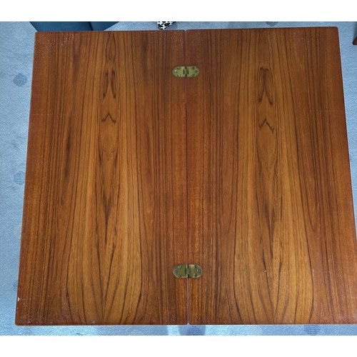 115 - A nest of 3 mid-century teak tables to include one fold over opening to form a larger table 81 x 76c... 