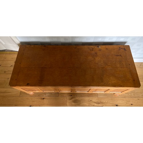 1162 - A Robert Mouseman Thompson panelled oak blanket box with hinged top on short octagonal baluster supp... 