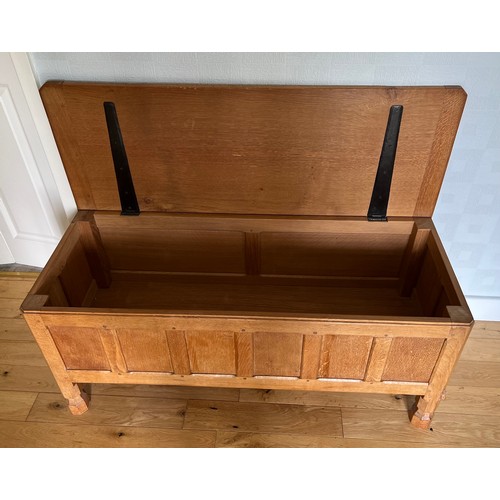 1162 - A Robert Mouseman Thompson panelled oak blanket box with hinged top on short octagonal baluster supp... 