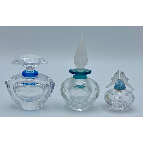 408 - Three Swarovski crystal perfume bottles with stoppers one with dolphins modelled to the stopper, tal... 