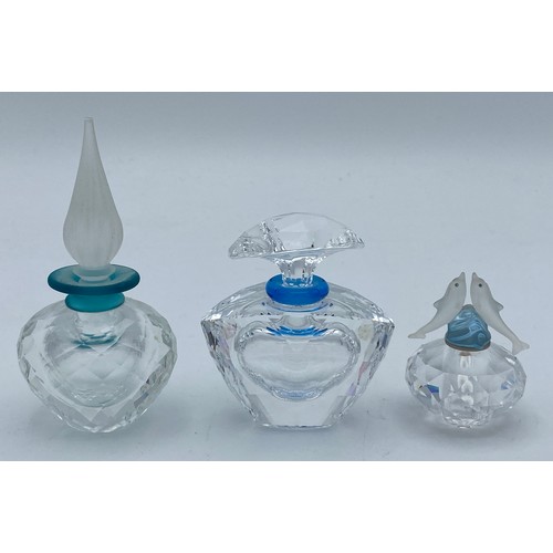 408 - Three Swarovski crystal perfume bottles with stoppers one with dolphins modelled to the stopper, tal... 