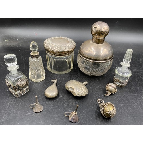 781 - A collection of silver and glass items to include four perfume bottles, perfume pendant, perfume bot... 