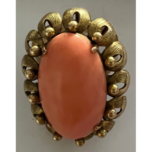 590 - A 14 carat gold cocktail ring, peach coloured stone set in flower head setting. 9.6gm total. Size N.