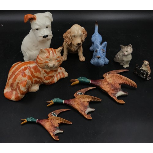 236 - A collection of ceramic animals to include a blue dog and two other dogs, a Just cat and a Royal Dou... 