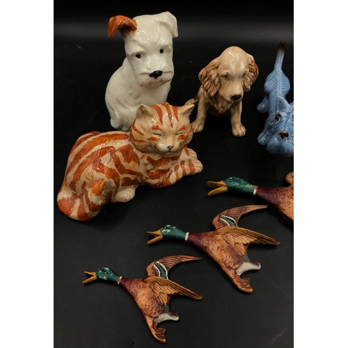 236 - A collection of ceramic animals to include a blue dog and two other dogs, a Just cat and a Royal Dou... 