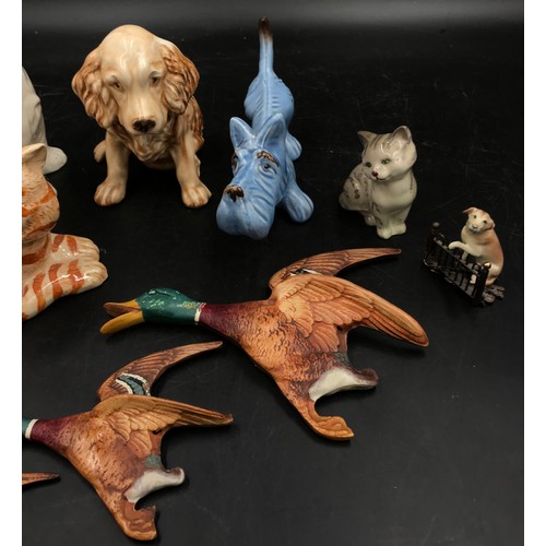 236 - A collection of ceramic animals to include a blue dog and two other dogs, a Just cat and a Royal Dou... 