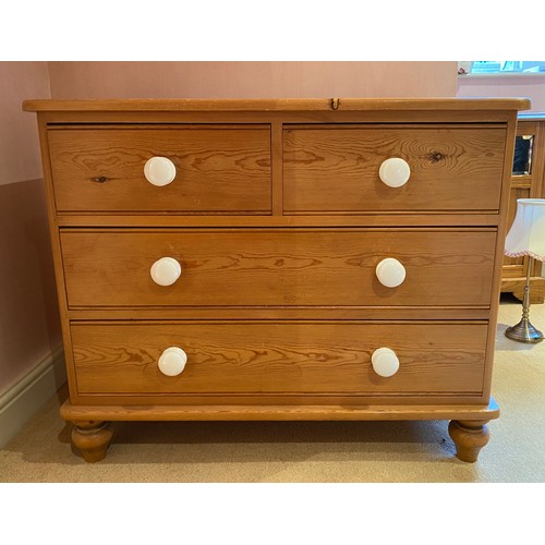 126 - A pine chest of drawers 2 short over 2 long with white porcelain knobs. 73 h x 90 w x 44cm d.